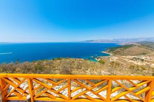 a view of the ocean from a yellow fence at Santa Oliva Suites in Ksamil