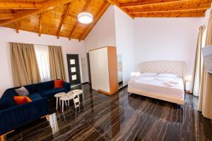 a living room with a bed and a blue couch at Santa Oliva Suites in Ksamil