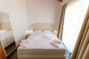 a bedroom with a bed and a window at Santa Oliva Suites in Ksamil