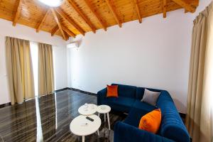 a living room with a blue couch and a table at Santa Oliva Suites in Ksamil