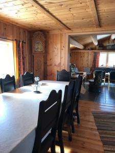 a dining room with a table and chairs and a clock at Fagerli Fjellgård in Høvringen