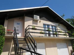 a house with a staircase leading to a balcony at Apartmani Lovro in Ogulin