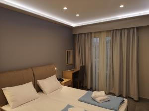 um quarto com uma cama, uma escrivaninha e uma janela em 3 Island View Hotel em Nydri