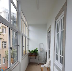 een hal met ramen en een tafel en een stoel bij Monte Agudo Angola 45 in Lissabon