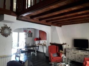 a living room with red chairs and a tv at Casa June in Torroella de Montgrí