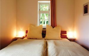 ein Schlafzimmer mit einem Bett mit zwei Kissen und einem Fenster in der Unterkunft Ferienhaus Gammelby Dorfstr. in Gammelby