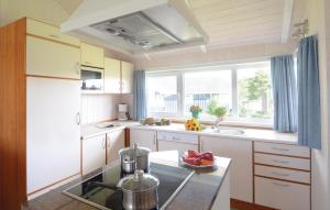 eine Küche mit weißen Schränken und einem großen Fenster in der Unterkunft Strandblick 10 - Dorf 1 in Travemünde