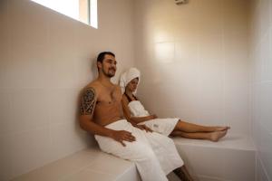 a man and a woman sitting on a bath tub at Solar Mirador Exclusive Resort e SPA in Praia do Rosa