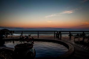 a hot tub with a view of the ocean at sunset at Solar Mirador Exclusive Resort e SPA in Praia do Rosa