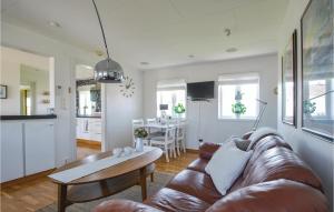 a living room with a brown leather couch and a table at 2 Bedroom Stunning Home In Borgholm in Borgholm