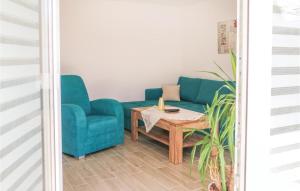 Una sala de estar con un sofá azul y una mesa. en 2 Bedroom Awesome Home In Zingst, en Zingst 6 fotos más