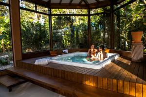 two children playing in a hot tub in a house at Solar Mirador Exclusive Resort e SPA in Praia do Rosa