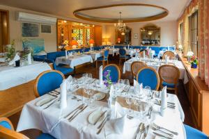 バーデンヴァイラーにあるArt-Hotel am Parkの白いテーブルと青い椅子が備わるレストラン