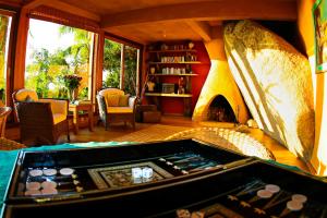 a living room with a pool table and a fireplace at Solar Mirador Exclusive Resort e SPA in Praia do Rosa