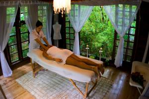 a woman sitting on a bed in a room at Solar Mirador Exclusive Resort e SPA in Praia do Rosa