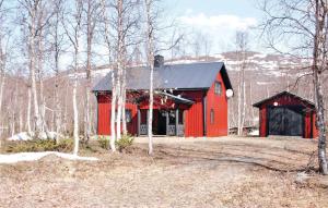 a red barn with a black roof in the woods at Stunning Home In Trnaby With Kitchen in Tärnaby