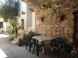 un tavolo e sedie seduti accanto a un muro di pietra di Apartment Lavender a Vela Luka (Vallegrande)