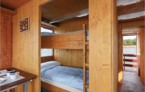 a bunk bed in a wooden cabin with a desk and a table at Nice Ship In Neustrelitz With House Sea View in Neustrelitz