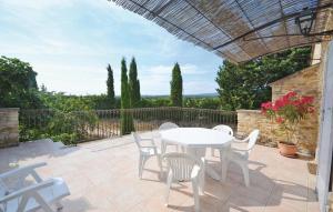 a patio with a white table and chairs on a patio at Lovely Home In Montbrison Sur Lez in Peyrol