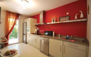 Nice Apartment In Saint Raphael With Outdoor Swimming Pool في سانت رافائيل: مطبخ بحائط احمر ومغسلة