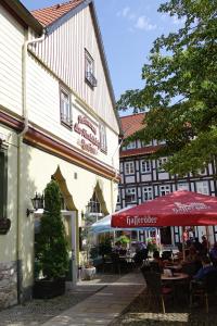 a building with a red umbrella and people sitting at a table at Pension "Am Nico" in Wernigerode