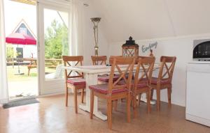 a dining room with a table and chairs and a kitchen at Bungalow 191 in Den Oever