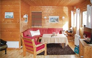 a living room with a red couch and a table at 3 Bedroom Stunning Home In Farsund in Farsund