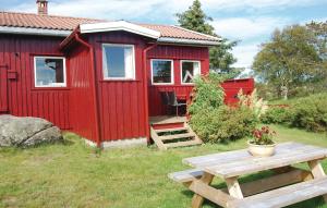 eine rote Hütte mit einem Picknicktisch davor in der Unterkunft Holiday Home Farsund Krågenes in Farsund