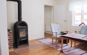 a living room with a fireplace and a table and chairs at 3 Bedroom Lovely Home In Dalum in Tomten