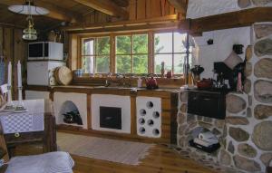 a kitchen with a stove and a stone wall at 2 Bedroom Awesome Home In Lnghem in Åkra