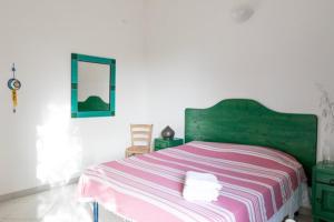 a bedroom with a green bed with a pink and white blanket at The Aia in Nardò