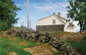 a stone wall in front of a white house at Nice Home In Manger With House Sea View in Manger