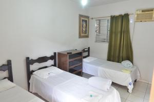 una habitación con dos camas y una ventana en HOTEL BEIRA RIO, en Ponte Nova