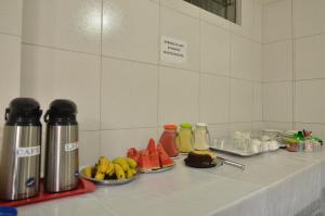 a counter with plates of fruit on a table at HOTEL BEIRA RIO in Ponte Nova