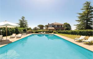 a swimming pool with chairs and a house at Tenuta Aliano in Corchiano