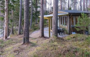 una cabaña en el bosque con mesa y sillas en Amazing Home In Vittsj With Kitchenette en Visseltofta