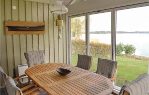 een eettafel en stoelen met uitzicht op het water bij 4 Bedroom Stunning Home In Ljungby in Bolmstad
