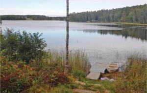 um barco sentado na margem de um lago em Nice Home In Grums With Kitchen em Västra Malsjö