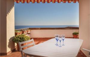 two wine glasses sitting on a white table on a balcony at Casa La Piazzetta in Ospedaletti
