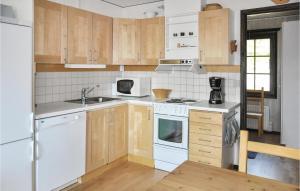 una cocina con electrodomésticos blancos y armarios de madera en Gorgeous Apartment In Slen With House A Mountain View, en Sälen