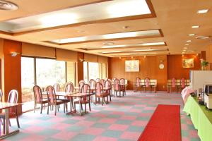 a dining room with tables and chairs andwindows at New Sunpia Saitama Ogose in Ogose