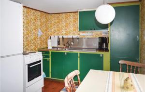 RydにあるStunning Home In Ryd With Internetのキッチン(緑のキャビネット、テーブル、白い電化製品付)