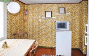 a kitchen with a refrigerator and a microwave on a wall at Awesome Home In Ryd With Kitchen in Ryd