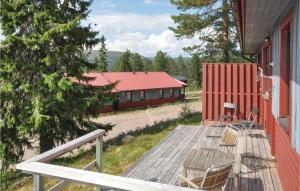 una terraza con sillas y un edificio rojo en Gorgeous Apartment In Slen With House A Mountain View, en Sälen