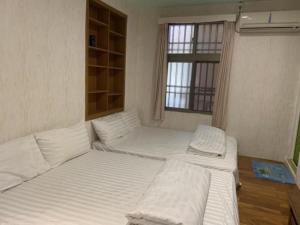 ein Zimmer mit drei Betten und einem Fenster in der Unterkunft 福緣白龍宮海景 in Xiaoliuqiu