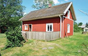 LinnerydにあるStunning Home In Linneryd With Kitchenetteの庭の柵付赤い家