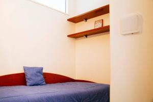 a small room with a bed with a blue pillow at Panoramic Beach View Apartment (T2) in Caparica in Costa da Caparica