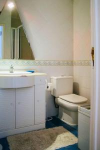 a bathroom with a sink and a toilet and a mirror at Panoramic Beach View Apartment (T2) in Caparica in Costa da Caparica +9 photos