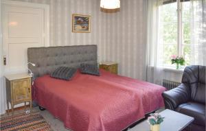 um quarto com uma cama com um cobertor vermelho e uma cadeira em 1 Bedroom Cozy Home In Virserum em Virserum