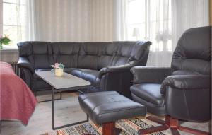 a living room with a leather couch and a chair at One-Bedroom Holiday Home In Virserum in Virserum